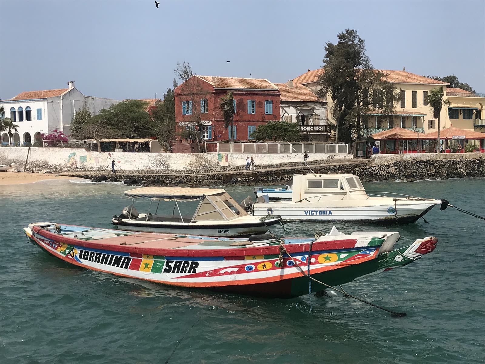 Une pirogue colorée amarrée devant les maisons de l'île de Gorée